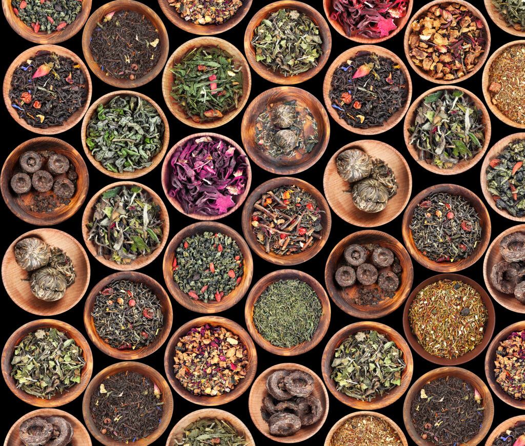 set of different tea in saucer on black background